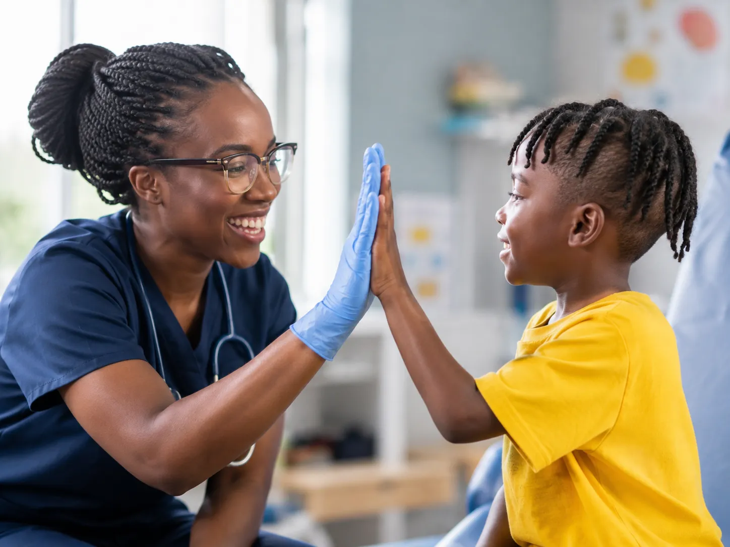 An LMCC nurse high-fiving a young patient